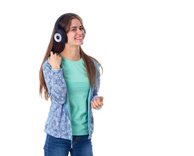 Jolie jeune femme aux longs cheveux bruns en chemise bleue dans un casque noir sur fond blanc en studio