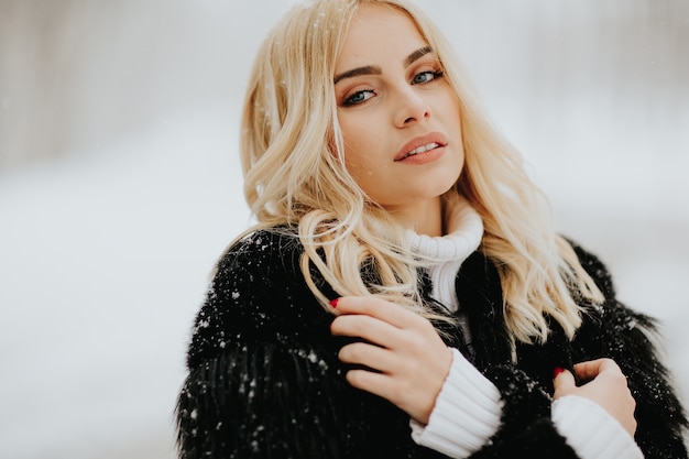 Jolie jeune femme blonde au jour d&#39;hiver enneigé