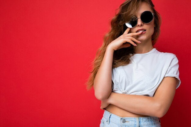 Jolie jeune femme blonde sexy portant des vêtements élégants de tous les jours et des lunettes de soleil modernes