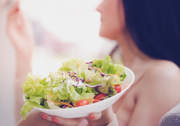 Jolie jeune femme en bonne santé mange de la salade verte pour un mode de vie sain