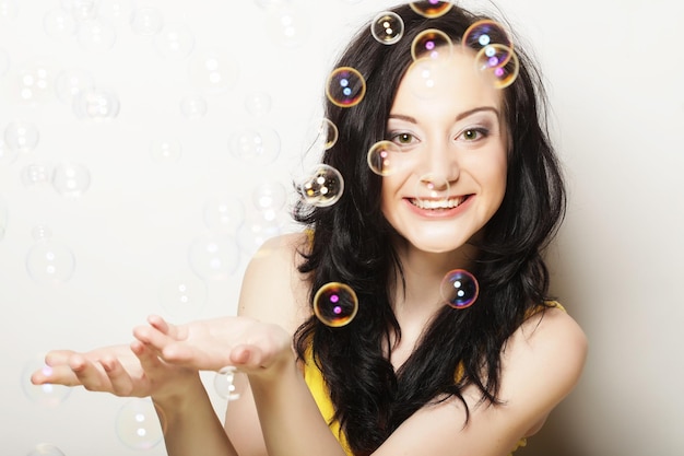 Jolie jeune femme avec des bulles de savon