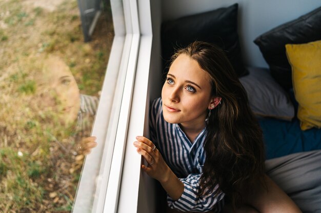 Photo jolie jeune femme caucasienne se détendre dans son appartement dans des vêtements confortables