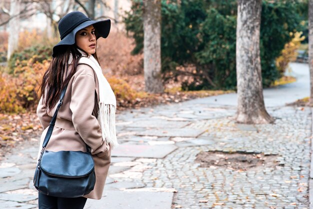 Jolie jeune femme avec chapeau dans le parc en automne