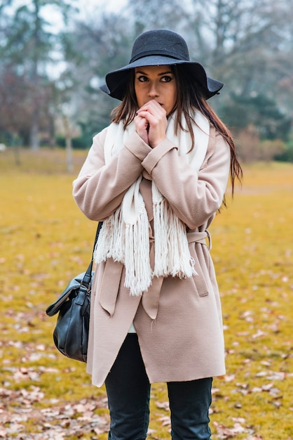 Jolie jeune femme avec chapeau dans le parc en automne