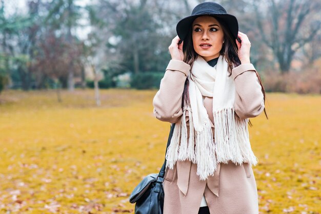 Jolie jeune femme avec chapeau dans le parc en automne