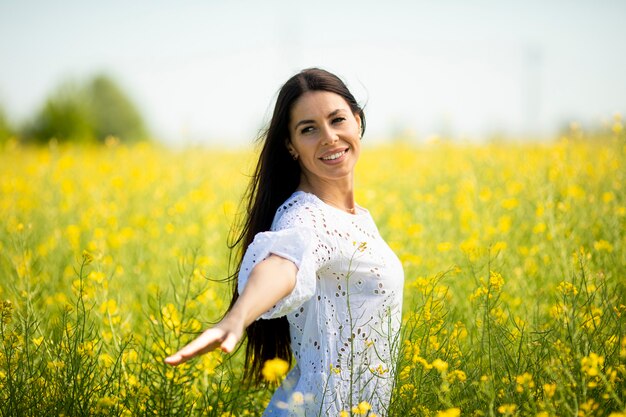 Jolie jeune femme dans le champ de colza