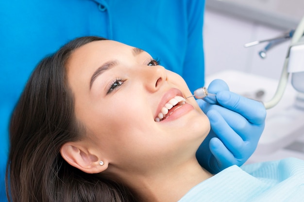 Jolie jeune femme dans une clinique dentaire avec un dentiste masculin. Concept de dents saines.