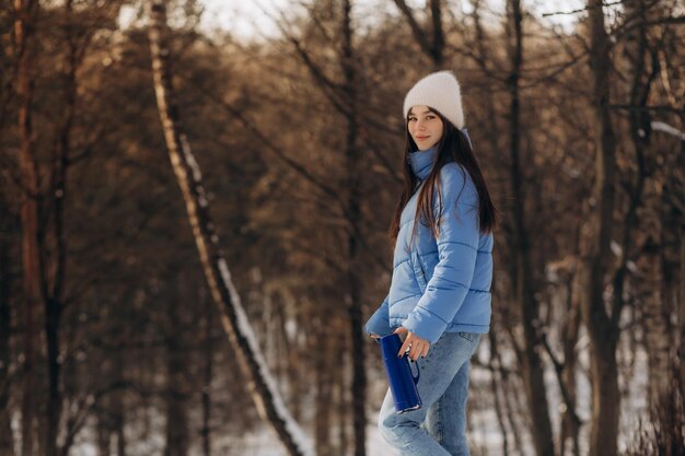 Une jolie jeune femme dans une élégante veste bleue tient une tasse dans ses mains Une image douce et chaleureuse