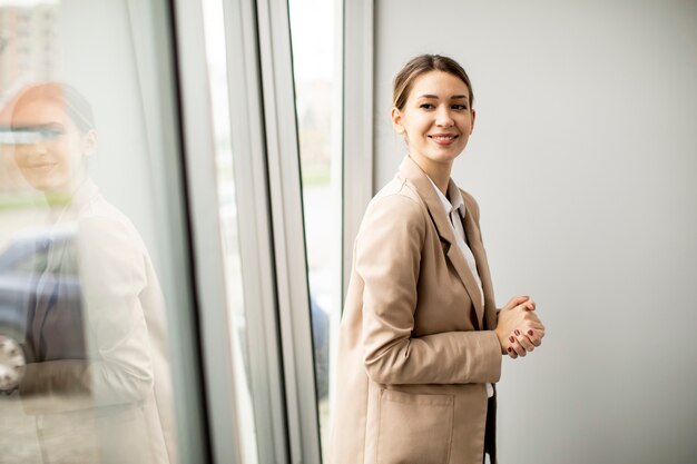 Jolie jeune femme debout dans un bureau moderne