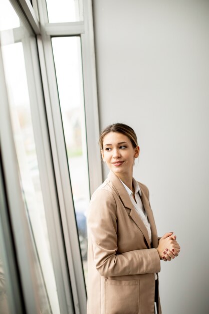 Jolie jeune femme debout dans un bureau moderne