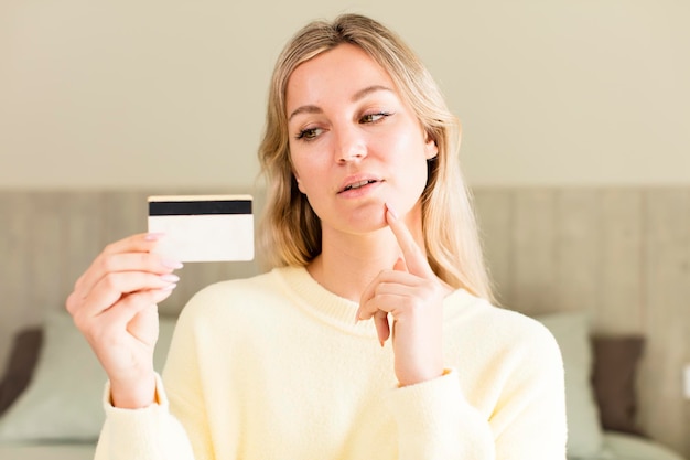 Jolie jeune femme avec un design d'intérieur de maison de concept d'argent de carte de crédit