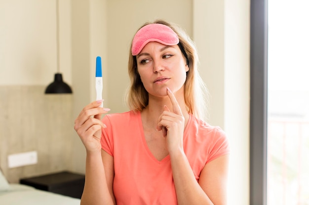 Jolie jeune femme avec un design d'intérieur de maison de test de grossesse