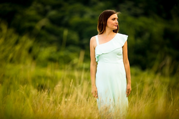 Jolie jeune femme enceinte se détendre à l'extérieur dans la nature au jour d'été