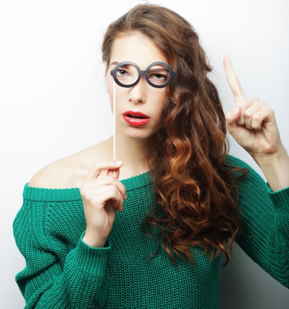 Jolie jeune femme espiègle avec de fausses lunettes prêtes pour la fête