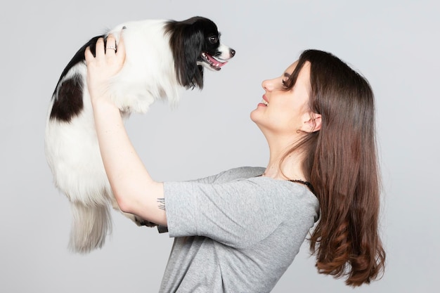 Une jolie jeune femme étreint son chiot papillon