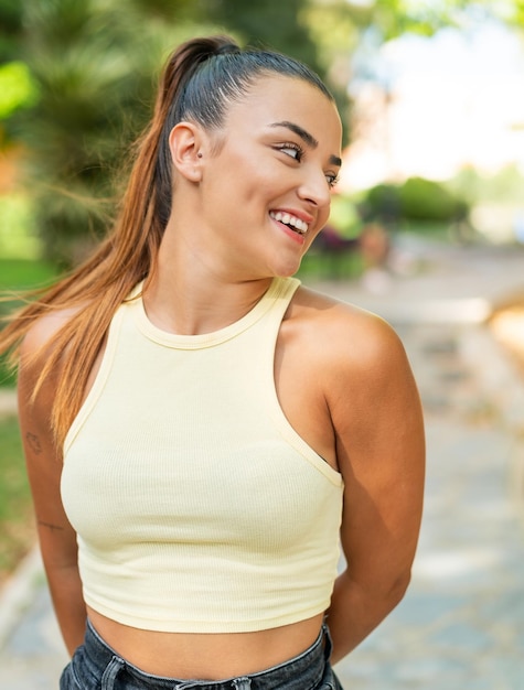 Une jolie jeune femme à l'extérieur avec une expression heureuse