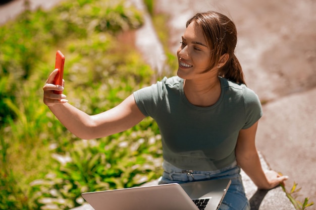 Jolie jeune femme faisant selfie et souriant