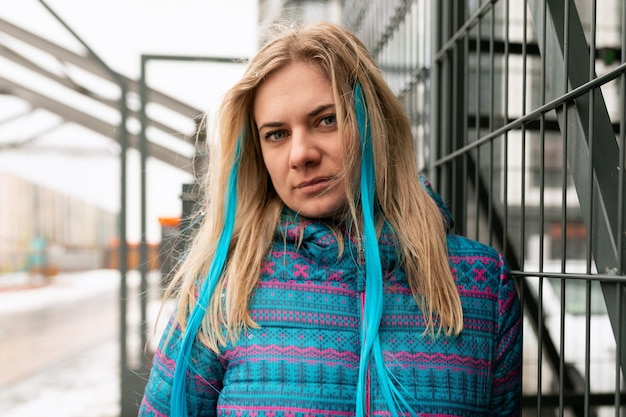 Une jolie jeune femme avec un fil coloré dans ses cheveux marche en hiver