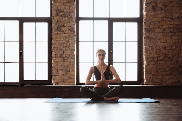 Jolie jeune femme fitness faire des exercices de yoga.