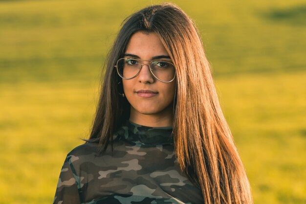 Jolie jeune femme sur fond de nature - gros portrait visage