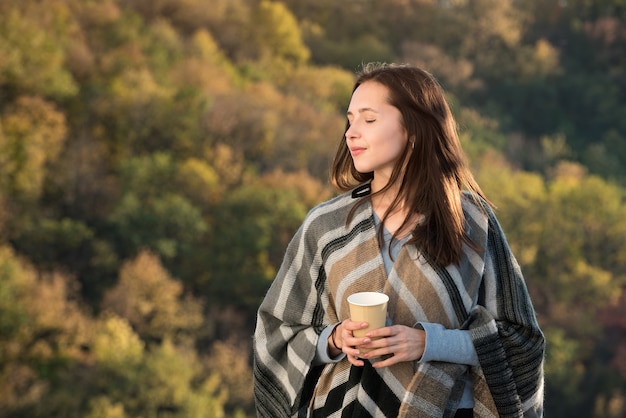 Jolie jeune femme sur une forêt d'automne de fond. Rêves d'humeur pensif.