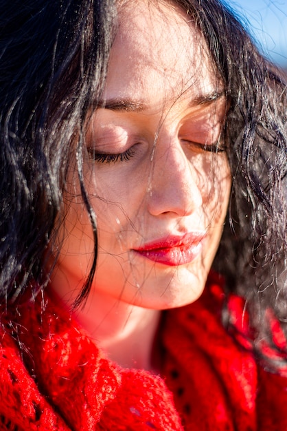 Jolie jeune femme avec un foulard rouge dans le parc