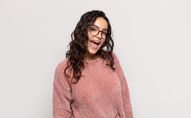 Jolie jeune femme avec un grand sourire amical et insouciant, à la recherche positive, détendue et heureuse, effrayante