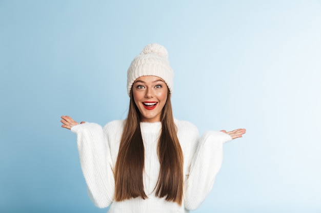 Jolie jeune femme incroyable portant un chapeau d'hiver, montrant copyspace.