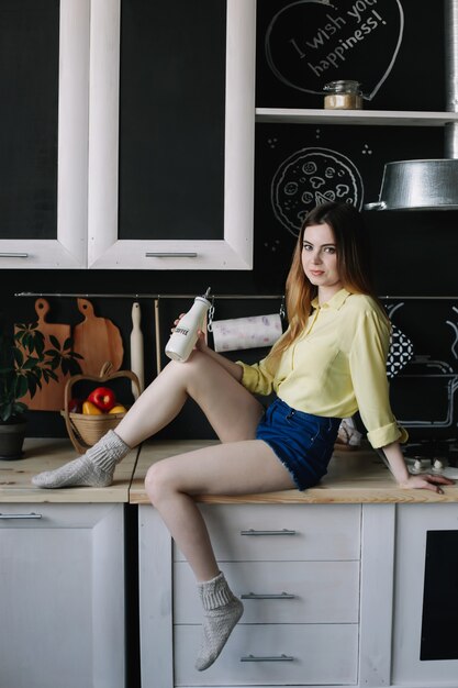 une jolie jeune femme à l'intérieur de la cuisine moderne