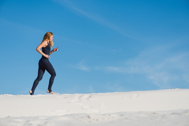 Jolie jeune femme jogging dans le désert