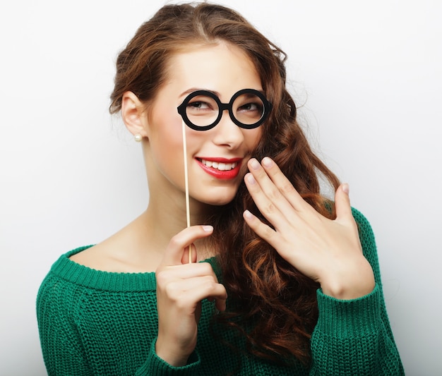 Jolie jeune femme ludique avec de fausses lunettes, prête pour la fête