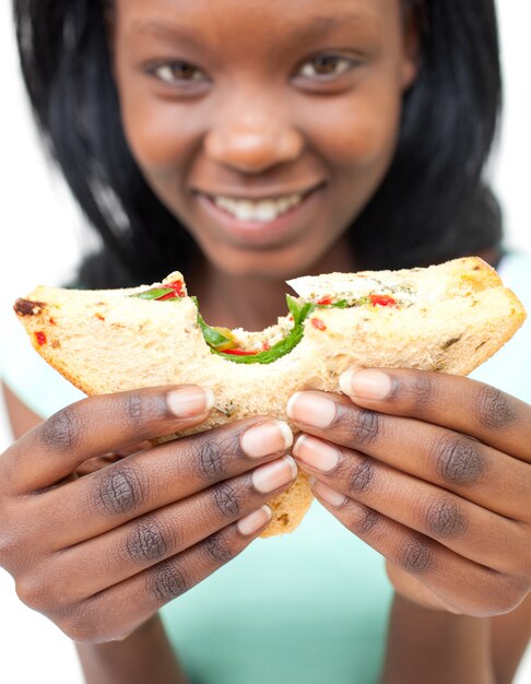 Jolie jeune femme mangeant un sandwich