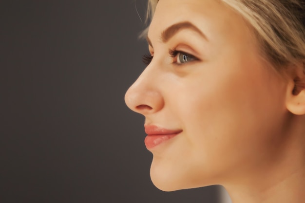 Jolie jeune femme avec un maquillage parfait. Gros plan sur le visage d'un joli modèle avec un maquillage naturel