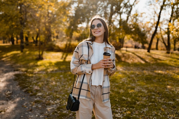 Jolie jeune femme marchant en automne portant une veste