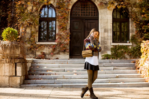 Jolie jeune femme marchant dans le parc en automne