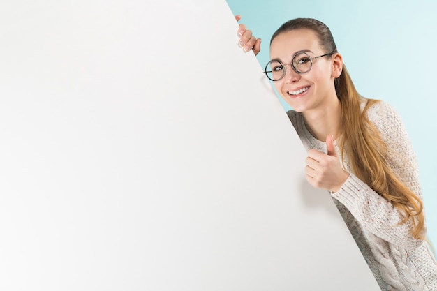 Jolie jeune femme avec mur blanc