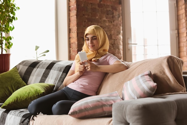 Une jolie jeune femme musulmane à la maison pendant la quarantaine et l'auto-isolement