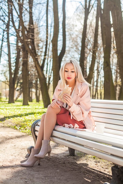 Jolie jeune femme avec de la nourriture de rue à l'extérieur