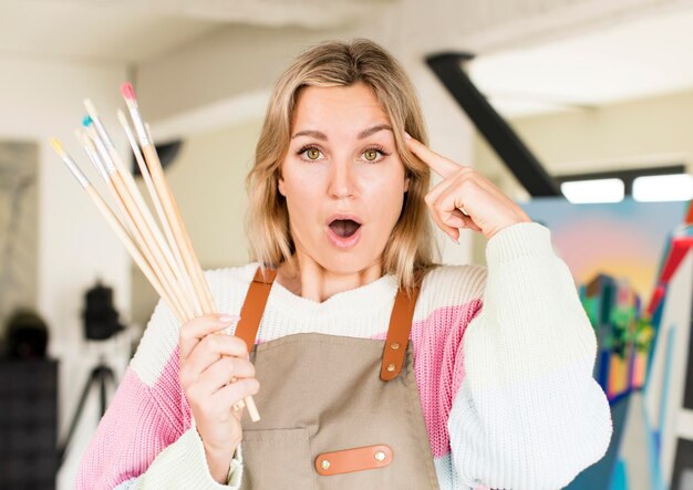 Photo jolie jeune femme peignant une œuvre d’art. notion d'artiste. design d'intérieur de maison