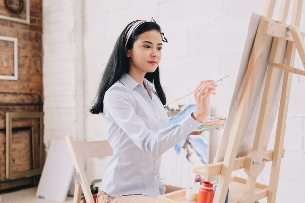 Jolie jeune femme peinture au chevalet