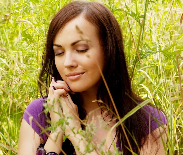 Jolie jeune femme en plein air dans l'herbe en été