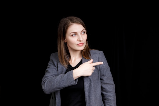 Une jolie jeune femme pointant vers le haut avec son doigt