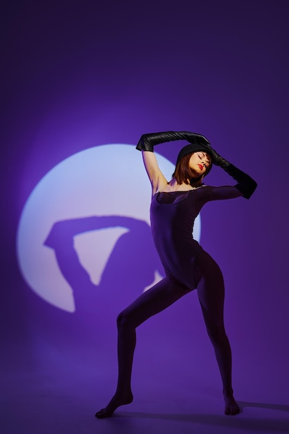 Jolie jeune femme posant sur scène projecteur silhouette disco fond de couleur inchangé