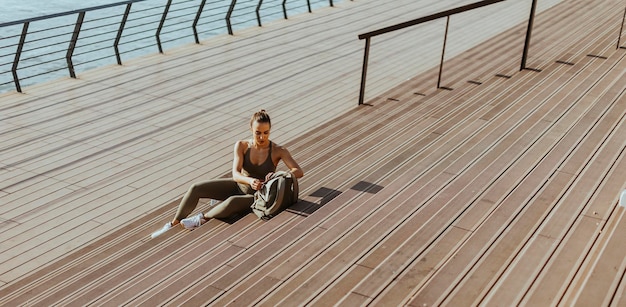 Jolie jeune femme prend une pause après avoir couru en zone urbaine