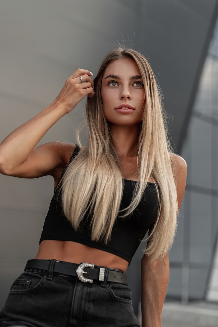 Photo jolie jeune femme de race blanche aux cheveux blonds en short en jean noir fashion avec débardeur noir dans la ville