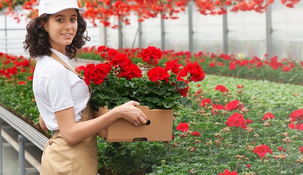 Jolie jeune femme ramasse des fleurs à vendre