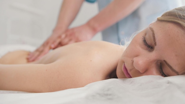 Jolie jeune femme recevant un massage au spa. Traitement de relaxation pour les épaules, médecine en gros plan