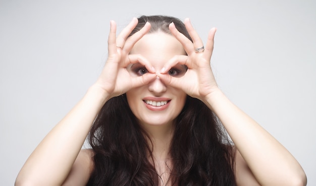 Jolie jeune femme à la recherche de quelque chose avec les yeux grands ouverts et