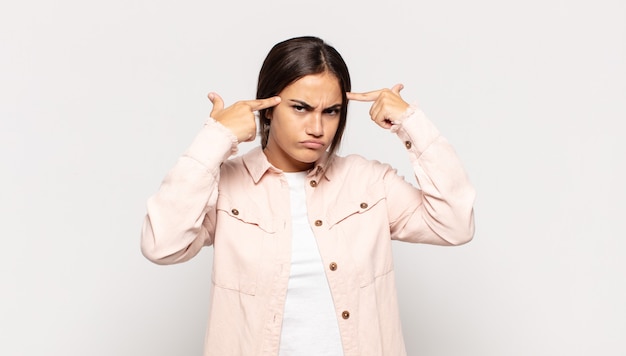 Jolie jeune femme avec un regard sérieux et concentré, un brainstorming et une réflexion sur un problème difficile