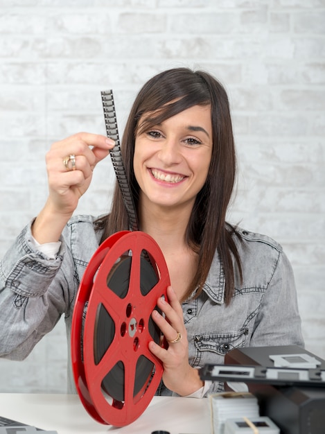 Jolie jeune femme regardant un film 16 mm